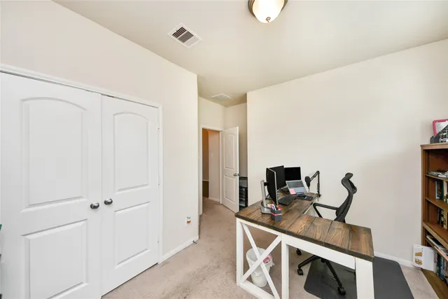 a view of a workspace with furniture and a window