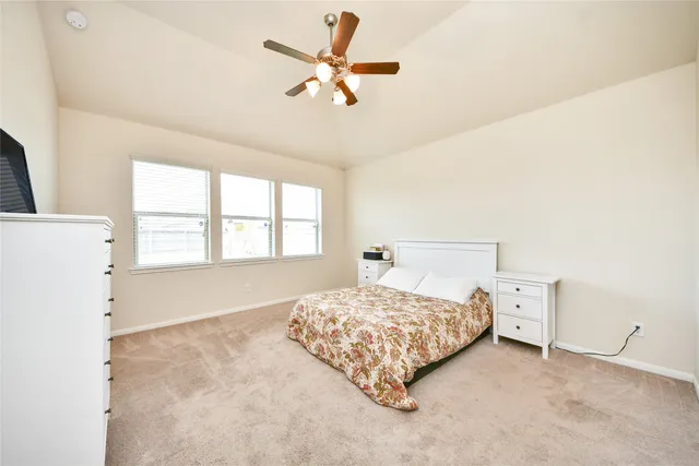 a bedroom with a bed and a large window