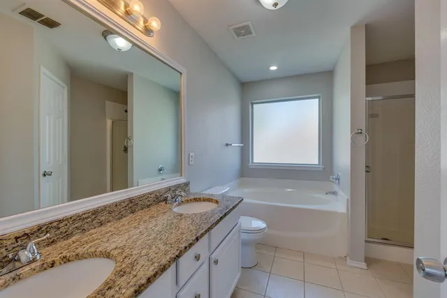 a bathroom with a granite countertop sink a toilet and bathtub