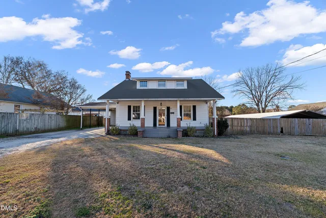 a front view of a house with a garden and trees