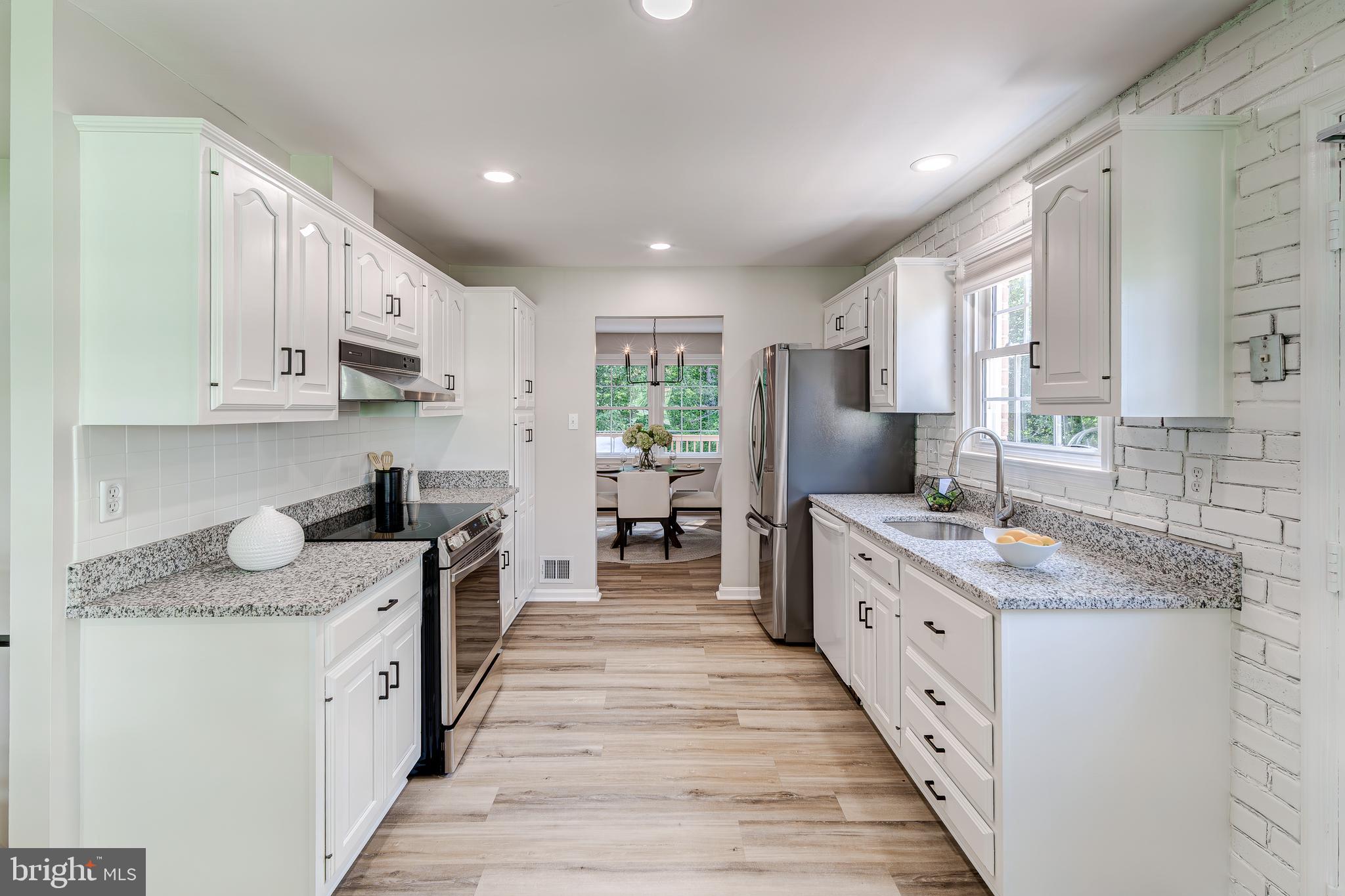 6803 Houndmaster Road Springfield, VA 22152 - Photo 17 of 44 a large kitchen with stainless steel appliances granite countertop a stove a sink dishwasher and cabinets with wooden floor