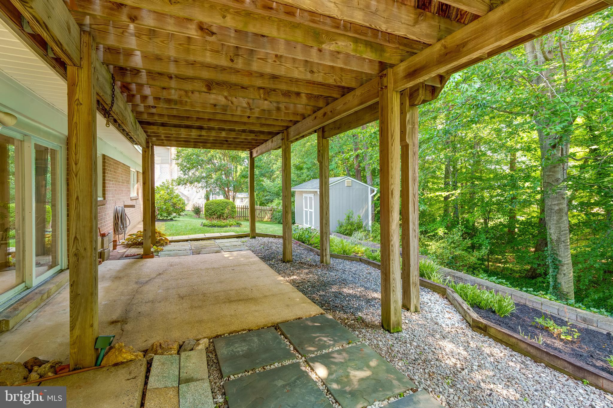 6803 Houndmaster Road Springfield, VA 22152 - Photo 42 of 44 a porch with a table and chairs next to a yard