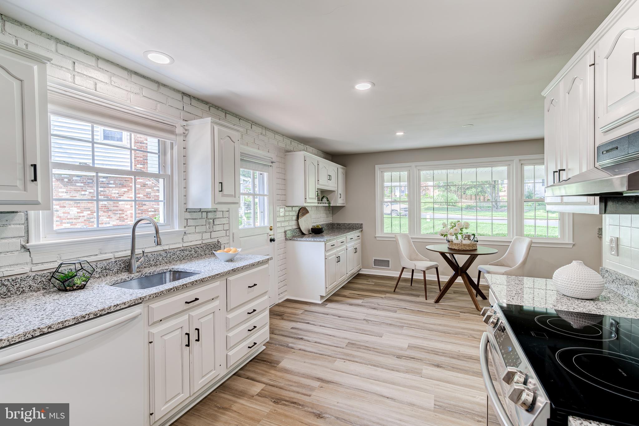 6803 Houndmaster Road Springfield, VA 22152 - Photo 6 of 44 a large kitchen with granite countertop a stove a sink a dining table and chairs