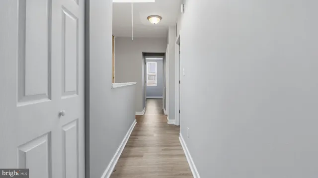 a view of a hallway with wooden floor