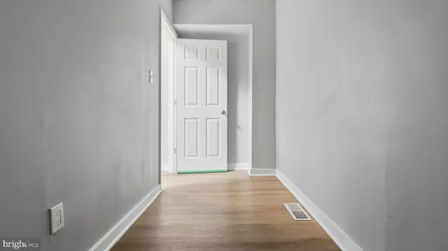 a view of a hallway with wooden floor