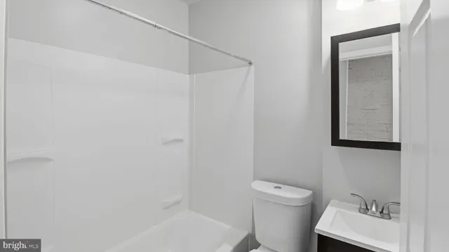 a bathroom with a toilet a sink and mirror