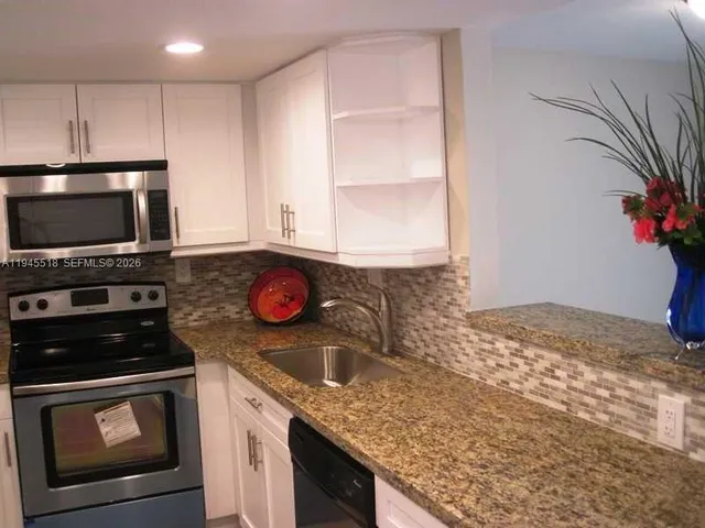 a view of kitchen with granite countertop stove top oven