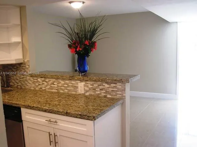 a view of a hallway with wooden floor and a potted plant