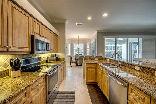 a large kitchen with stainless steel appliances granite countertop a lot of counter space and a sink