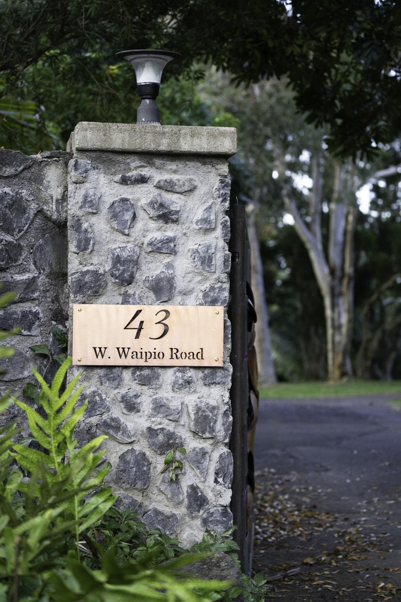 43 West Waipio Road Haiku, HI 96708 - Photo 2 of 44 a sign that is sitting on a brick wall