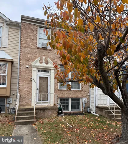 a view of a white house with large windows and a tree