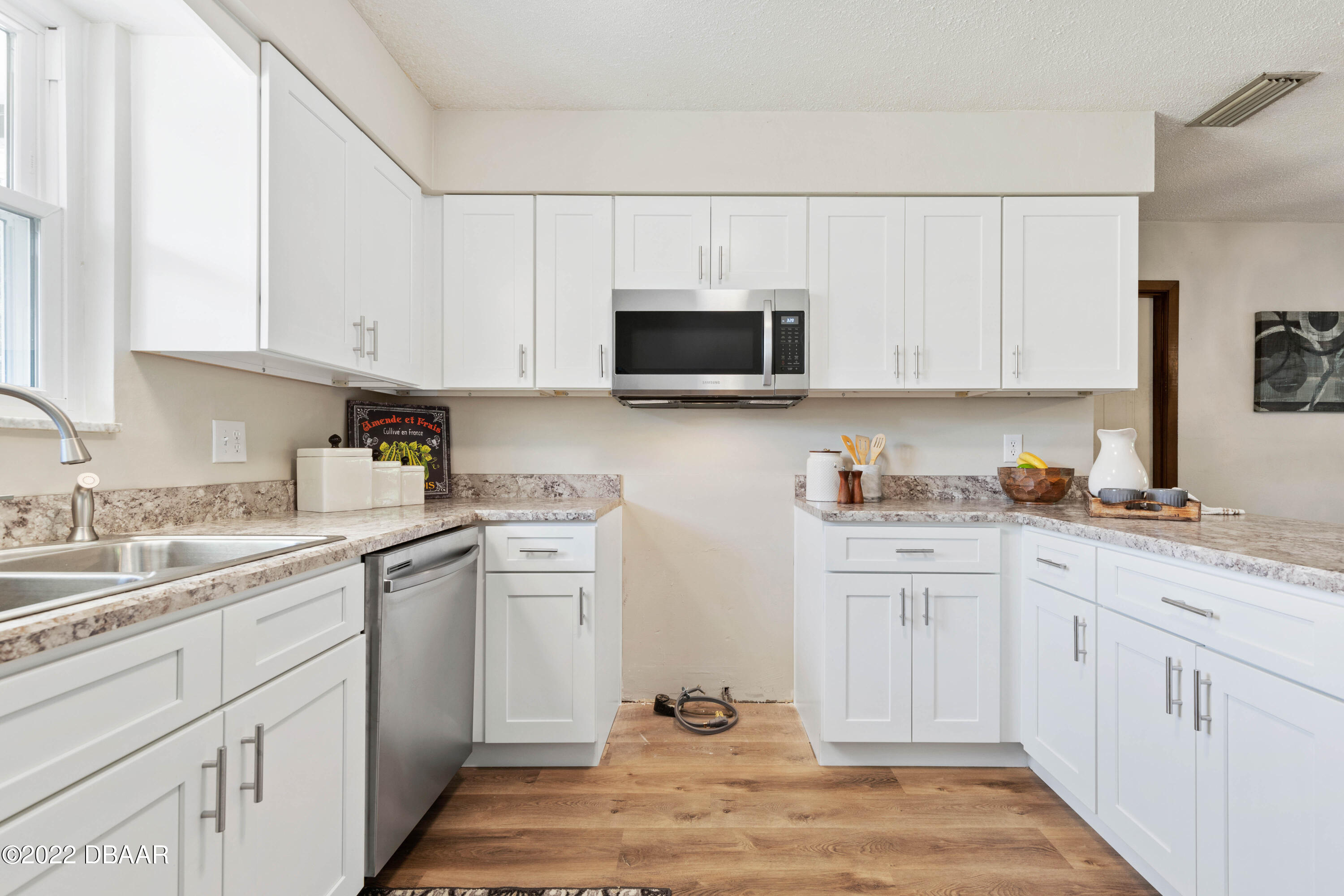 64 Cumberland Avenue Ormond Beach, FL 32174 - Photo 11 of 38 a kitchen with cabinets appliances a sink and a counter top space