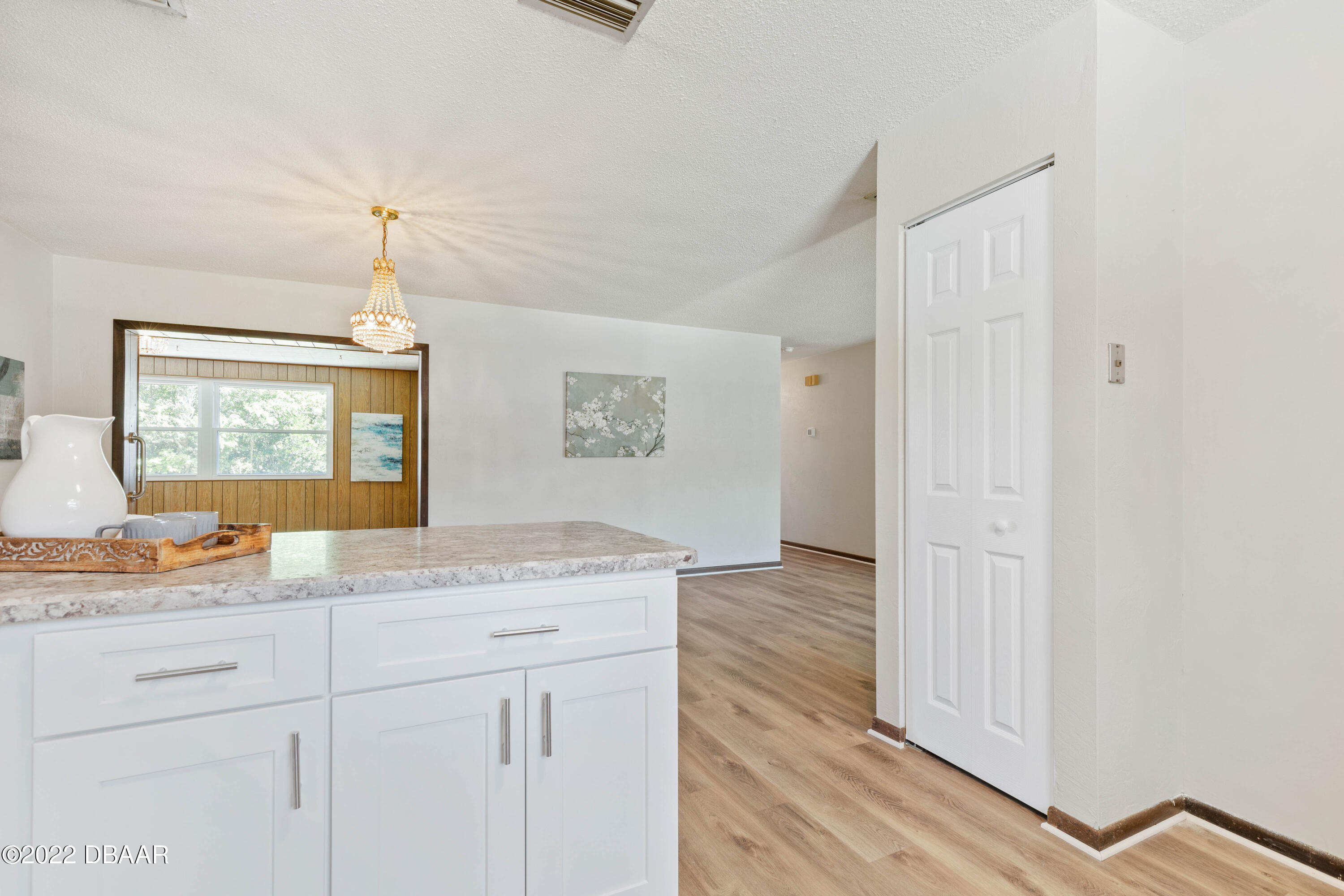 64 Cumberland Avenue Ormond Beach, FL 32174 - Photo 13 of 38 a hall with kitchen island white cabinets and wooden floor