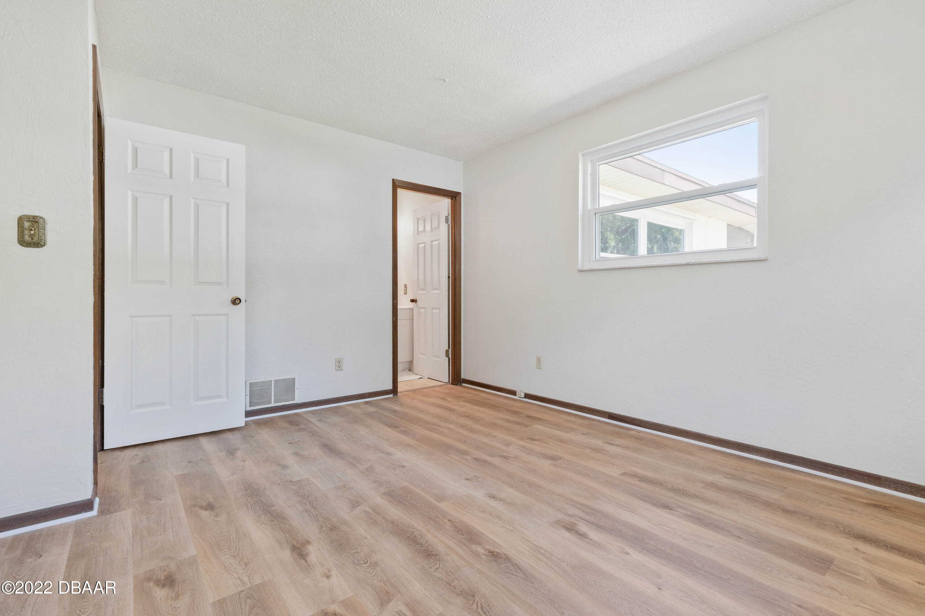 64 Cumberland Avenue Ormond Beach, FL 32174 - Photo 18 of 38 a view of an empty room with wooden floor and a window