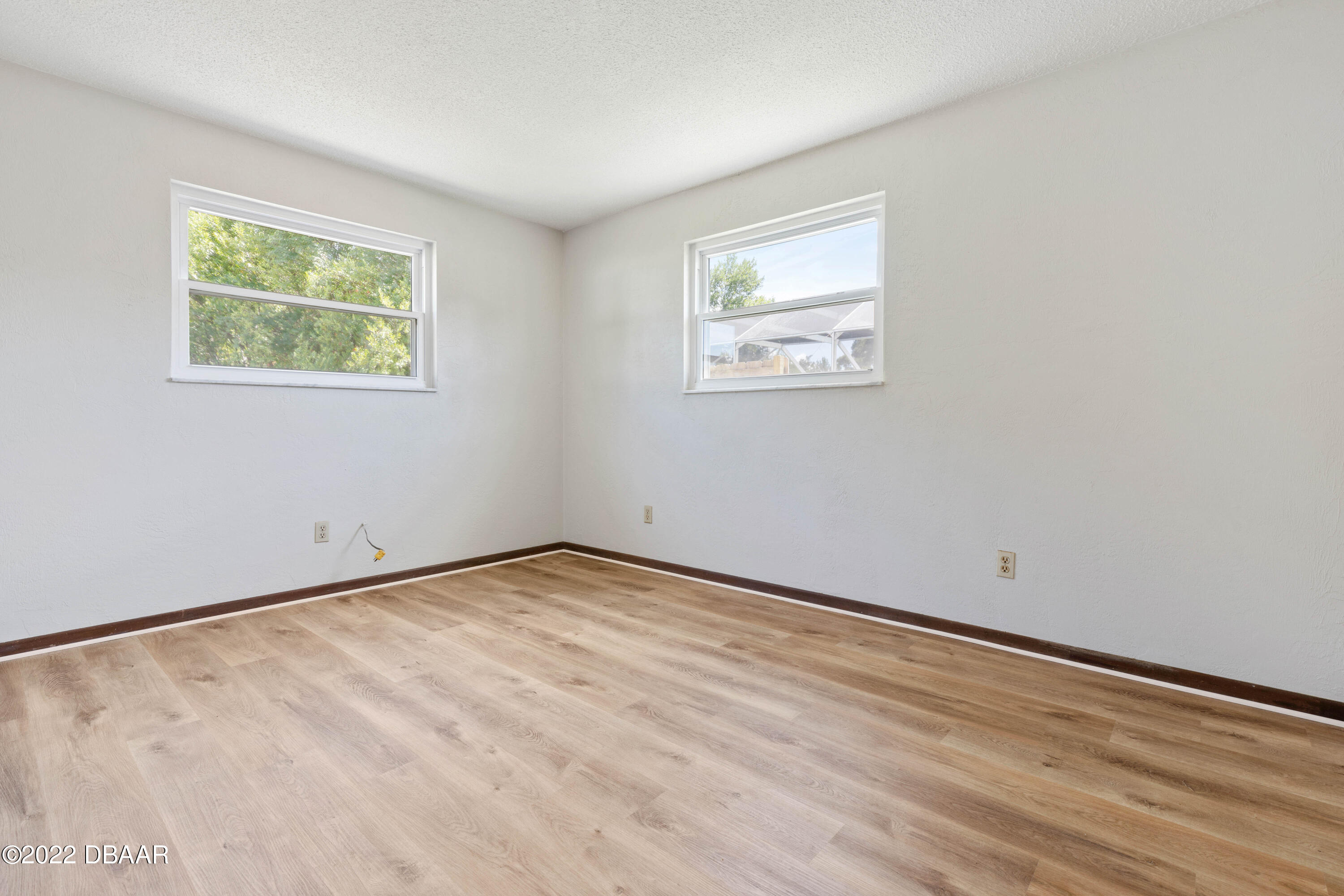 64 Cumberland Avenue Ormond Beach, FL 32174 - Photo 20 of 38 a view of an empty room with wooden floor and a window