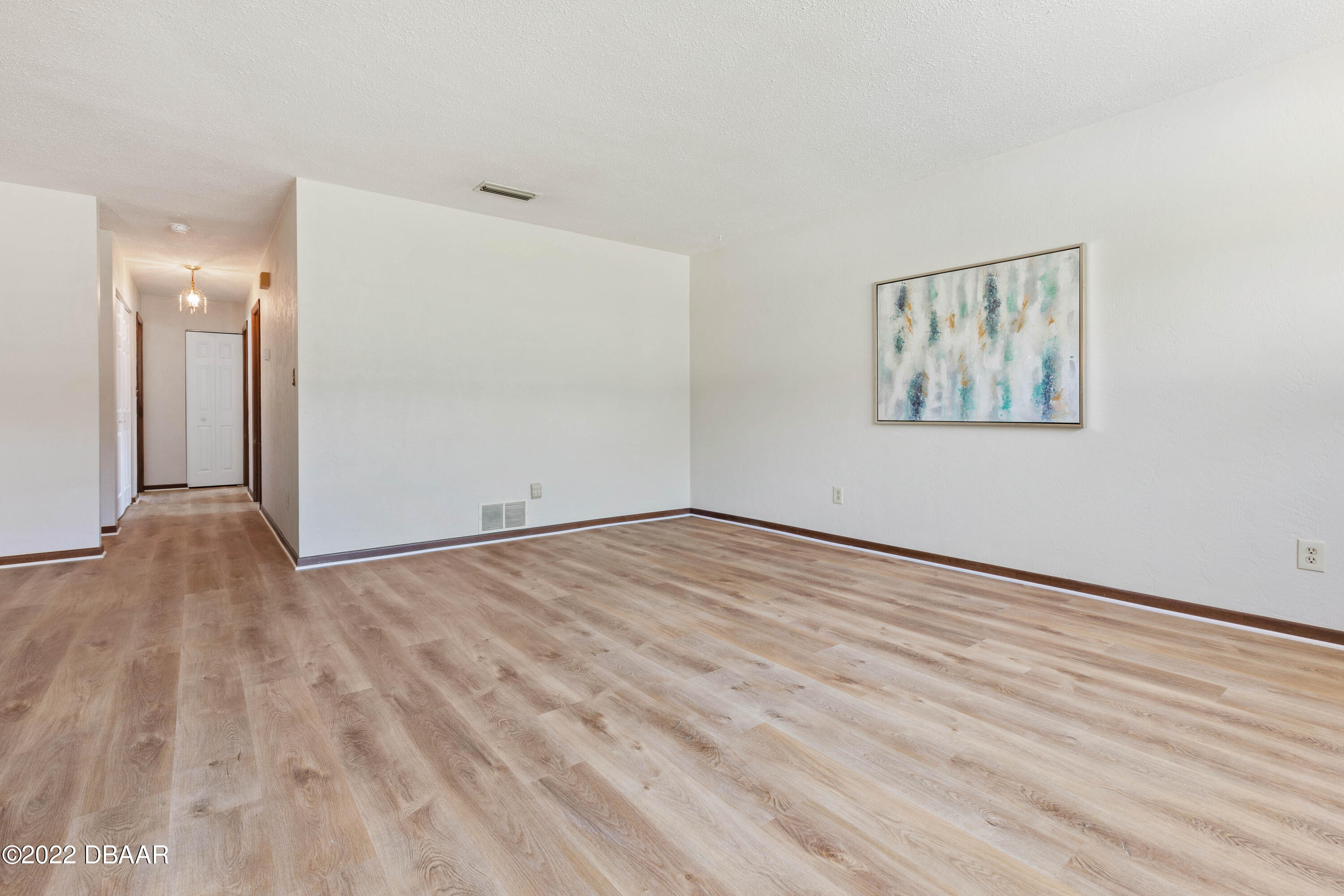 64 Cumberland Avenue Ormond Beach, FL 32174 - Photo 7 of 38 an empty room with wooden floor and windows