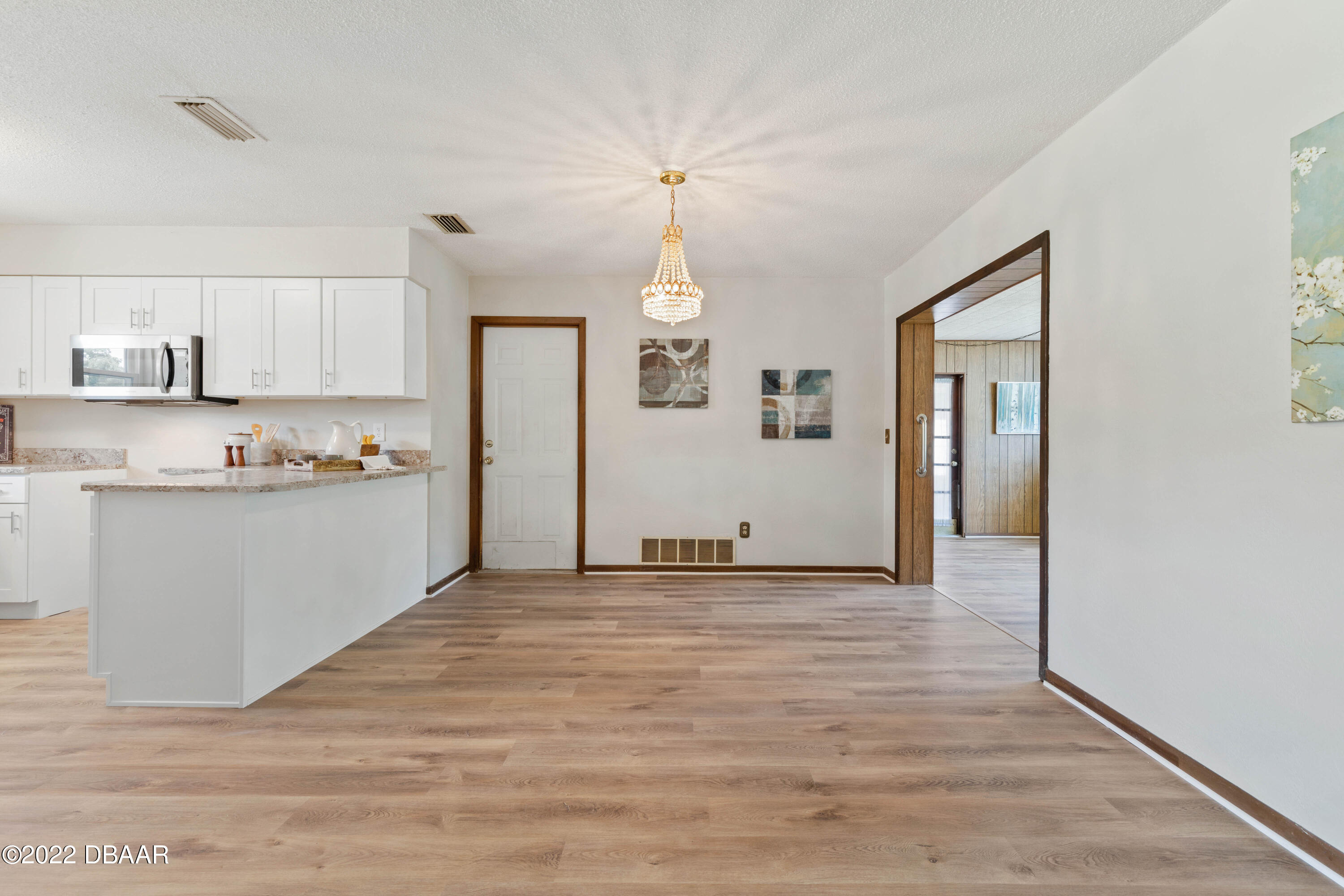 64 Cumberland Avenue Ormond Beach, FL 32174 - Photo 8 of 38 a view of a kitchen with wooden floor and windows