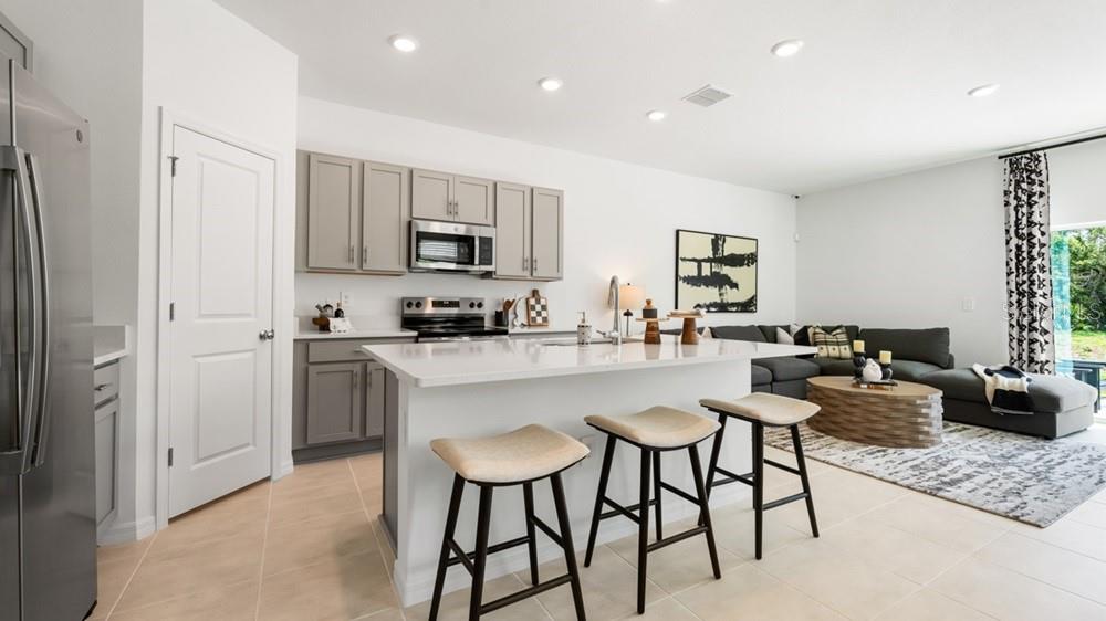 10770 Eclipse Street Sarasota, FL 34241 - Photo 11 of 48 a kitchen with kitchen island granite countertop wooden cabinets and stainless steel appliances