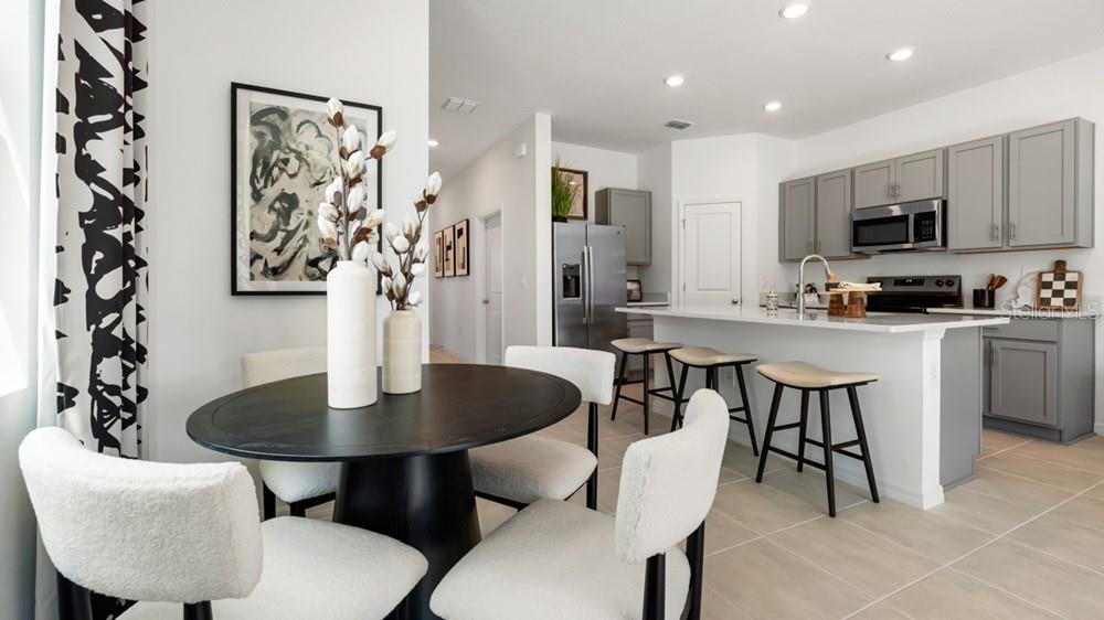10770 Eclipse Street Sarasota, FL 34241 - Photo 12 of 48 a kitchen with stainless steel appliances a dining table and chairs