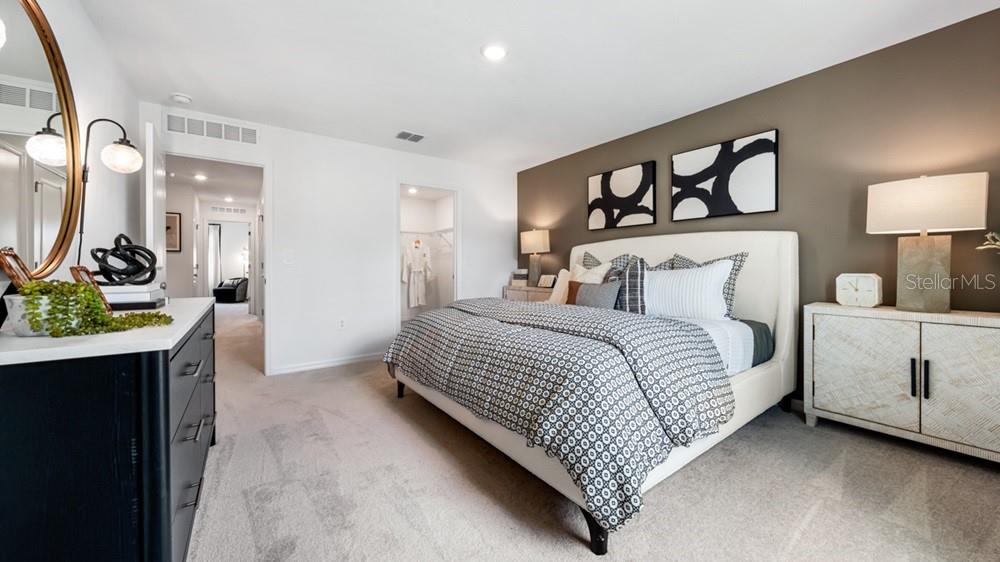 10770 Eclipse Street Sarasota, FL 34241 - Photo 15 of 48 a bedroom with a bed a mirror on dresser and a table