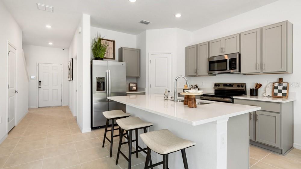 10770 Eclipse Street Sarasota, FL 34241 - Photo 7 of 48 a kitchen with stainless steel appliances granite countertop a refrigerator a stove a sink a microwave and white cabinets with wooden floor