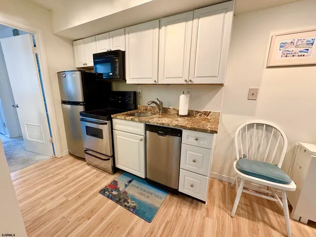 a kitchen with stainless steel appliances a refrigerator sink and microwave