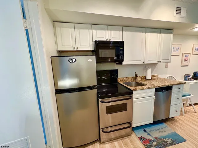 a kitchen with stainless steel appliances granite countertop a stove a sink and a refrigerator