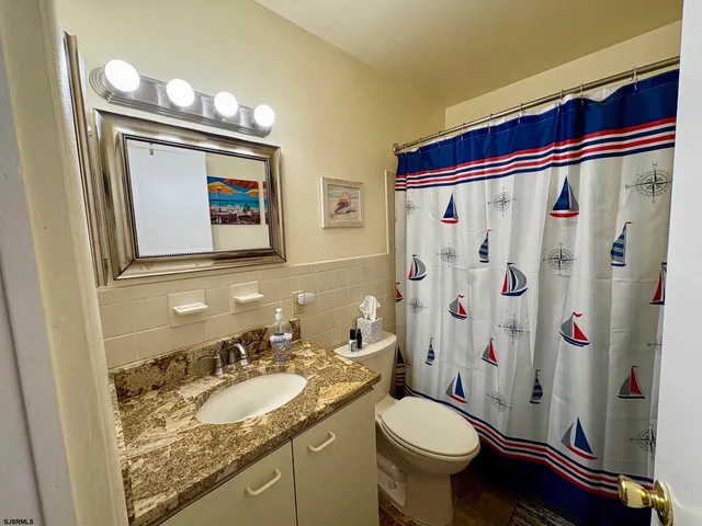 a bedroom with a bed a chair and a flat screen tv