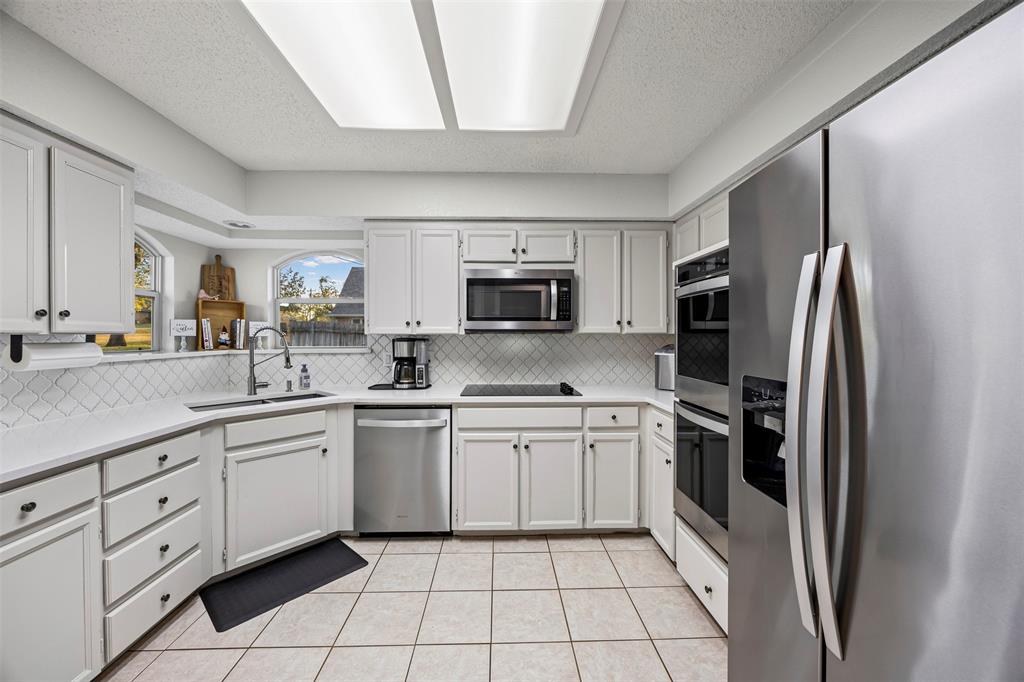 112 Saddle Hills Road Burleson, TX 76028 - Photo 14 of 38 a kitchen with stainless steel appliances granite countertop a refrigerator and a stove top oven