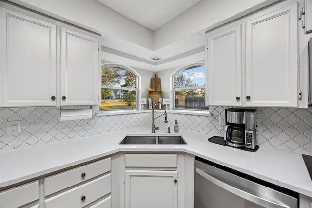 a kitchen with stainless steel appliances white cabinets and a granite counter tops