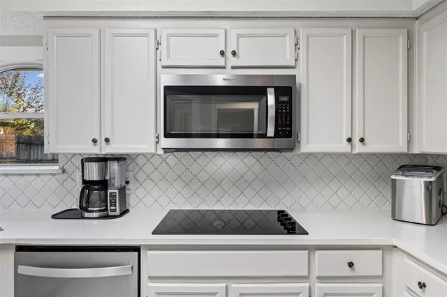 a kitchen with a stove and a white cabinet