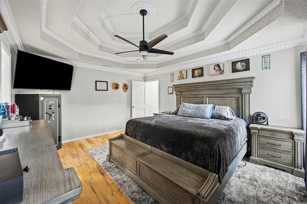 112 Saddle Hills Road Burleson, TX 76028 - Photo 19 of 38 a bedroom with a bed a flat screen tv and a couch