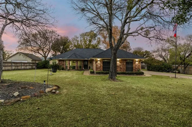 a view of a house with backyard and trees