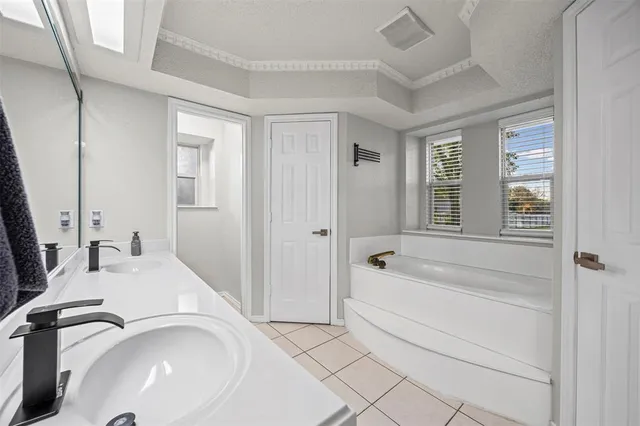 a bathroom with a tub sink and mirror