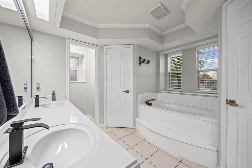 112 Saddle Hills Road Burleson, TX 76028 - Photo 21 of 38 a bathroom with a tub sink and mirror