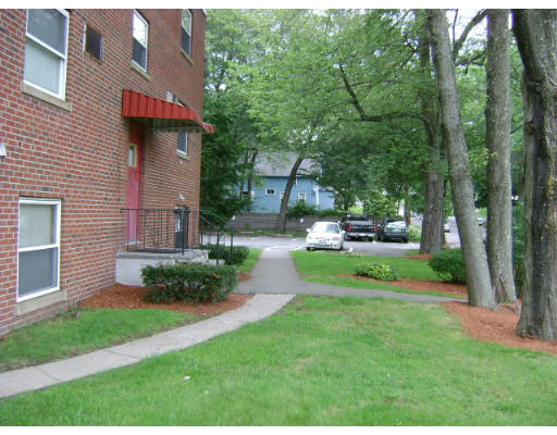 150 Main Street, Unit 9 Stoneham, MA 02180 - Photo 2 of 11 a front view of a house with a yard and trees