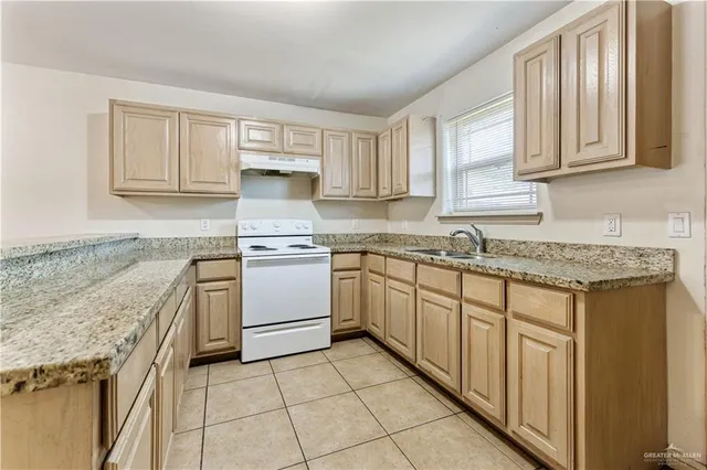 a kitchen with granite countertop white cabinets and white appliances
