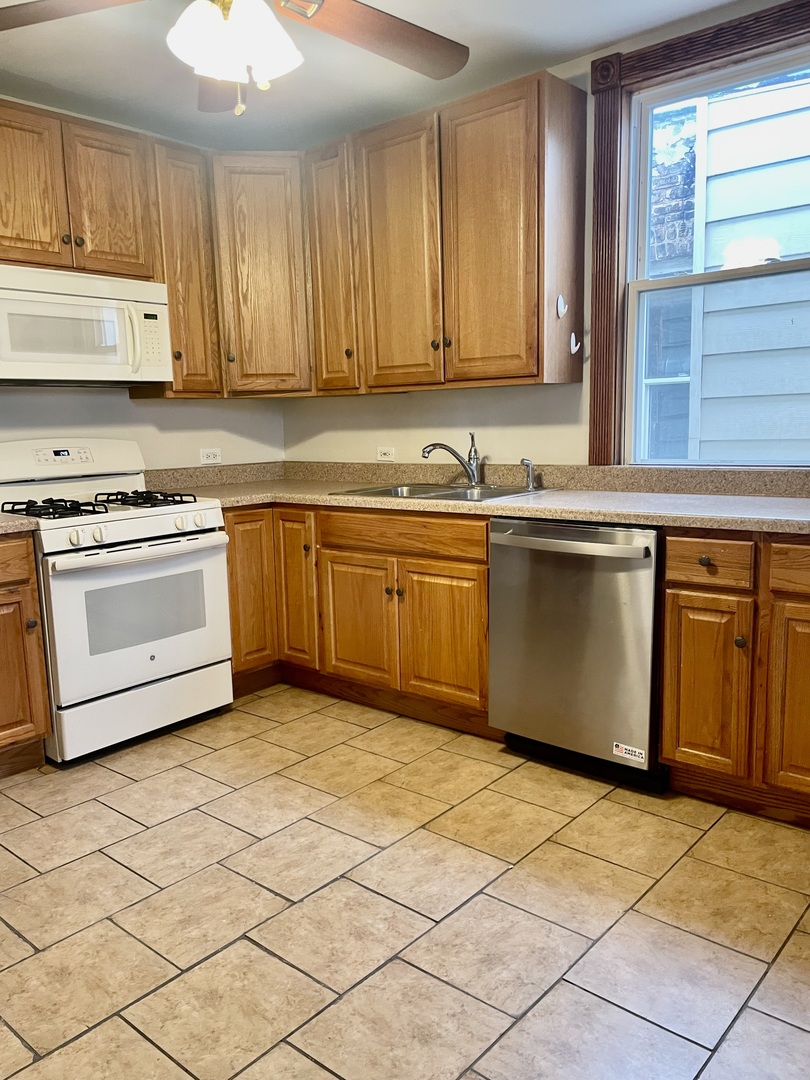 Undisclosed Address Chicago, IL 60618 - Photo 11 of 14 a kitchen with stainless steel appliances granite countertop a stove a sink and a microwave