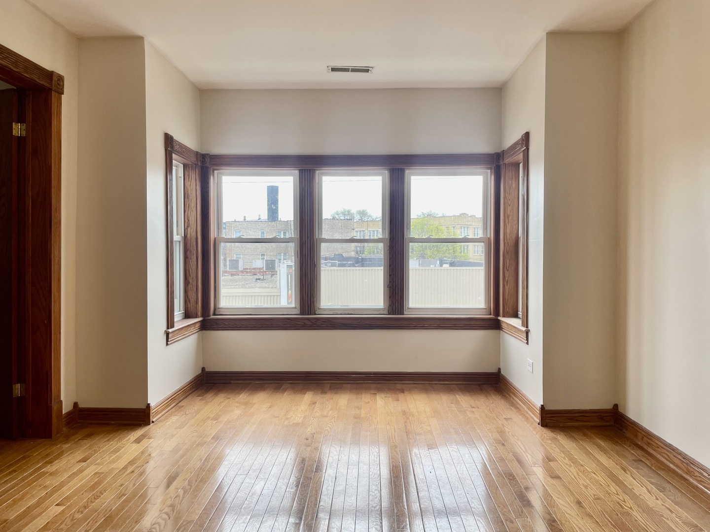 Undisclosed Address Chicago, IL 60618 - Photo 3 of 14 an empty room with wooden floor and windows
