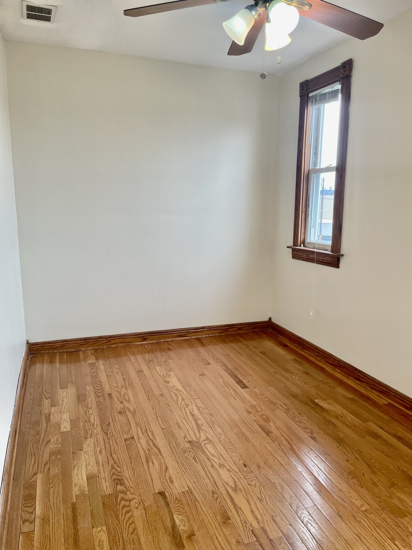 Undisclosed Address Chicago, IL 60618 - Photo 8 of 14 a view of empty room with wooden floor and fan