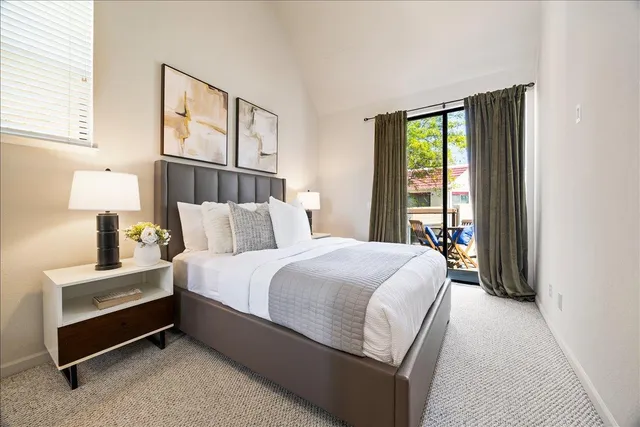 a bedroom with a bed and a desk next to a window