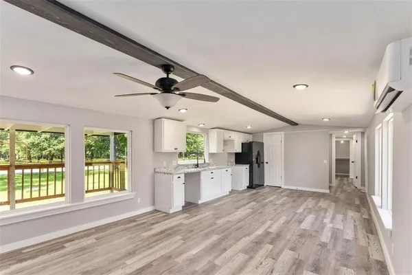 a large space with chandelier fan and windows