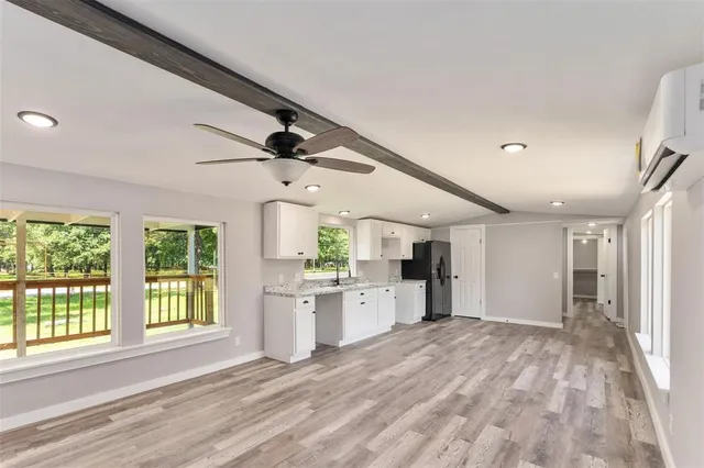 a large space with chandelier fan and windows