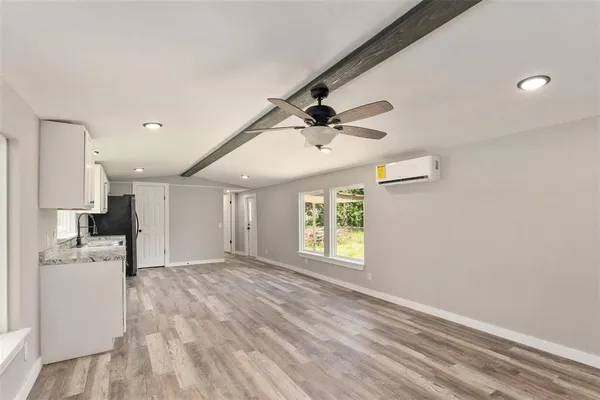 a view of empty room with wooden floor and window