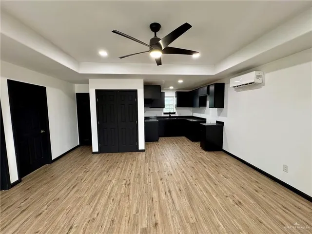 a view of a kitchen with wooden floor and a ceiling fan