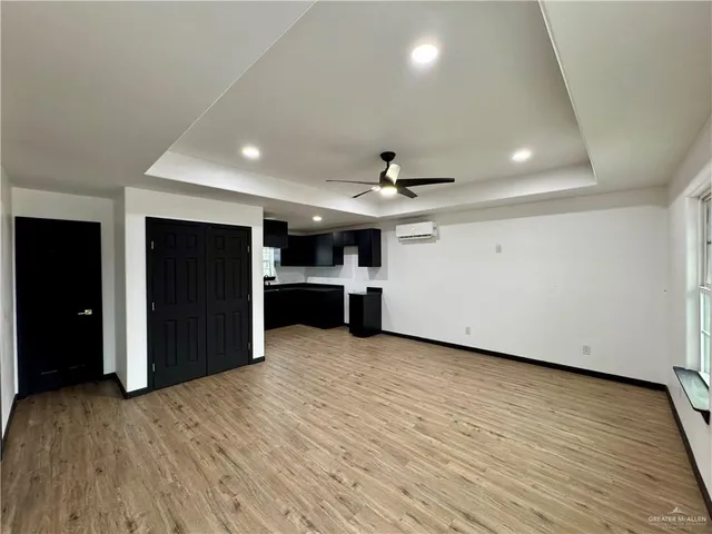 a view of a big room with wooden cabinet and a ceiling fan