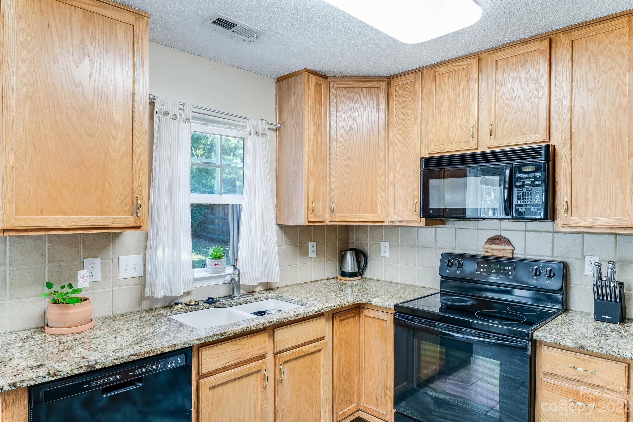 513 Red Oak Court Tega Cay, SC 29708 - Photo 6 of 21 a kitchen with granite countertop stainless steel appliances a sink stove and cabinets
