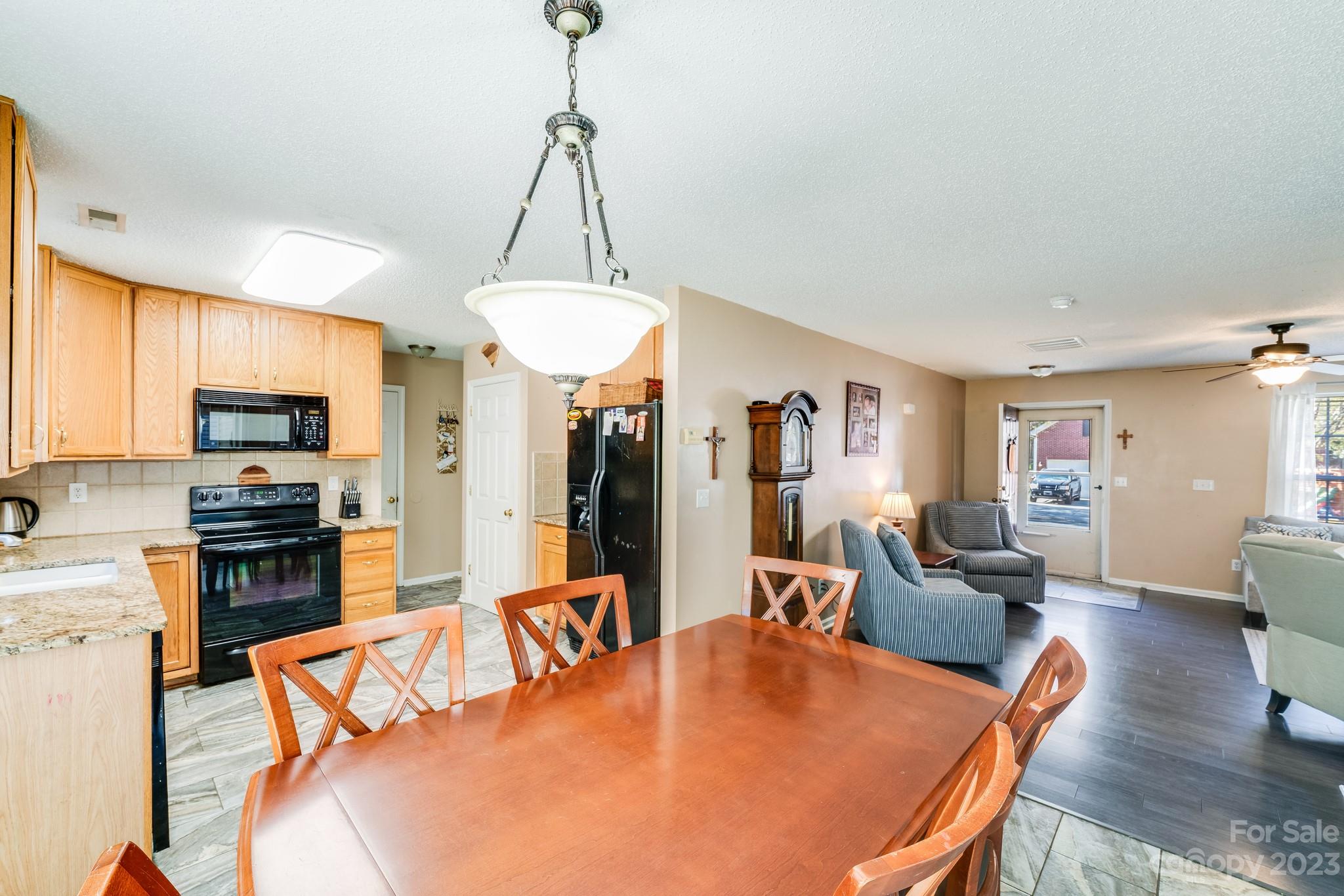 513 Red Oak Court Tega Cay, SC 29708 - Photo 7 of 21 a living room with stainless steel appliances furniture a couch a dining table and a chandelier