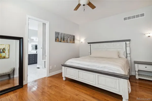 a bedroom with a bed and painting on the wall