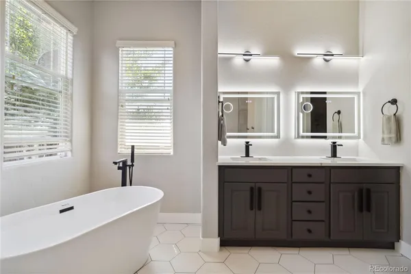 a spacious bathroom with a tub sink and mirror